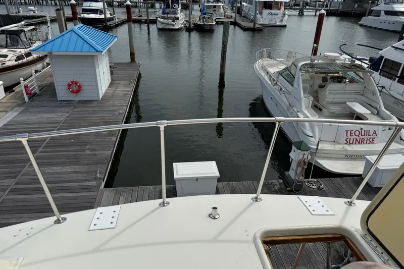 Slide: The Image of 1981 Hatteras 43 Motor Yacht docked at marina with nearby boats and pier. - 19