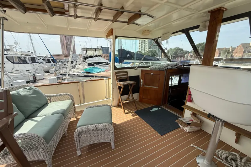 Slide: The Image of Interior of 1981 Hatteras 43 Motor Yacht with wicker seating and marina view. - 32