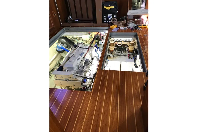 Slide: The Image of Engine room of 1981 Hatteras 43 Motor Yacht with exposed machinery and wooden flooring. - 64