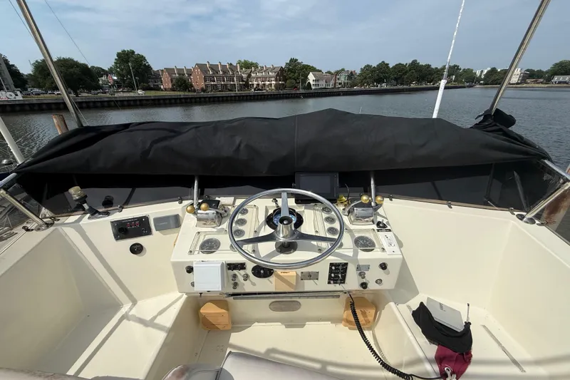 Slide: The Image of Cockpit of 1981 Hatteras 43 Motor Yacht with steering wheel and control panel, docked by waterfront. - 35