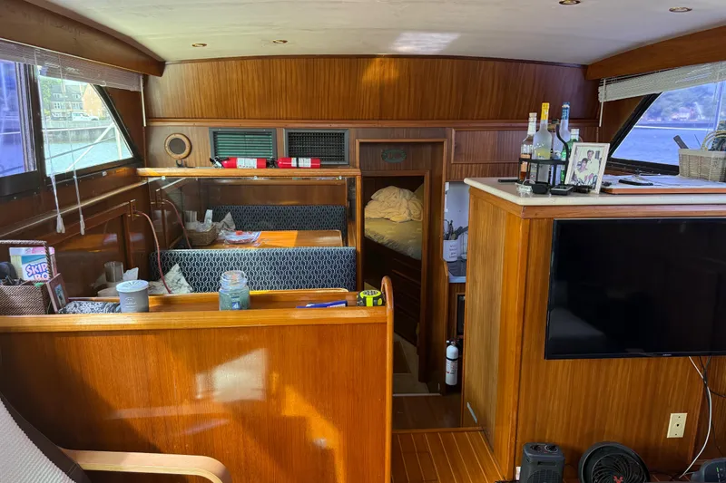 Slide: The Image of Interior of 1981 Hatteras 43 Motor Yacht with wood paneling and cozy seating area. - 39