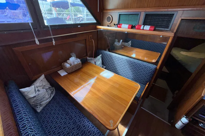 Slide: The Image of Interior of 1981 Hatteras 43 Motor Yacht with wooden dining area and blue seating. - 40
