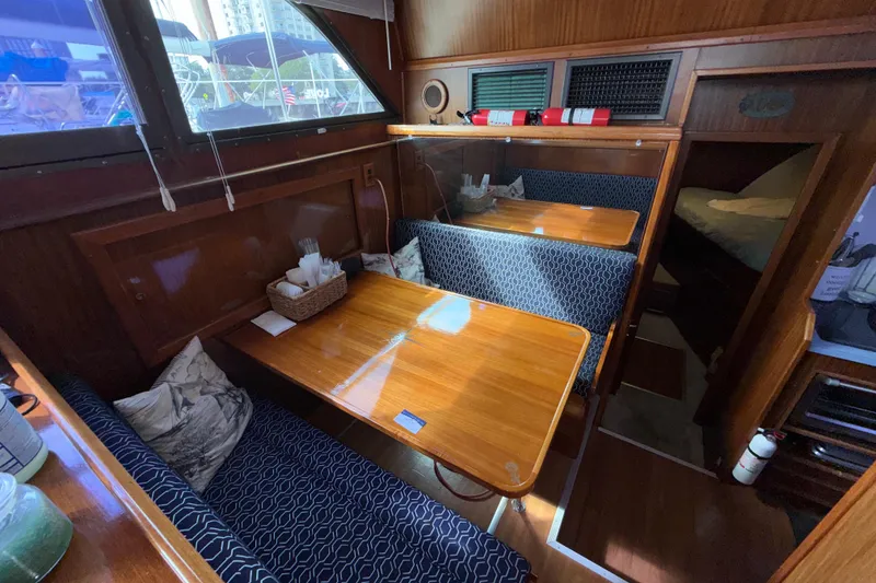 Slide: The Image of Interior of 1981 Hatteras 43 Motor Yacht with wooden dining area and blue seating. - 41