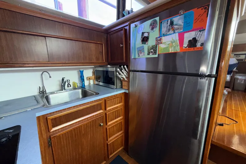 Slide: The Image of 1981 Hatteras 43 Motor Yacht kitchen with stainless steel fridge and wooden cabinetry. - 42