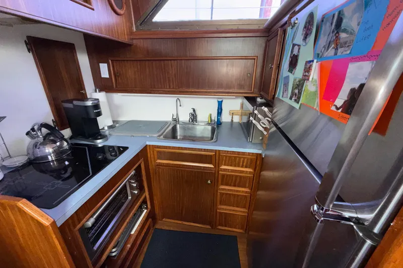 Slide: The Image of Compact kitchen in 1981 Hatteras 43 Motor Yacht with wood cabinetry and modern appliances. - 44
