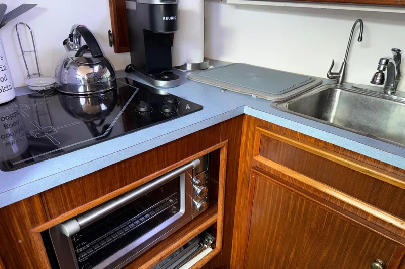 Slide: The Image of Compact kitchen in a 1981 Hatteras 43 Motor Yacht with stove, sink, and appliances. - 45