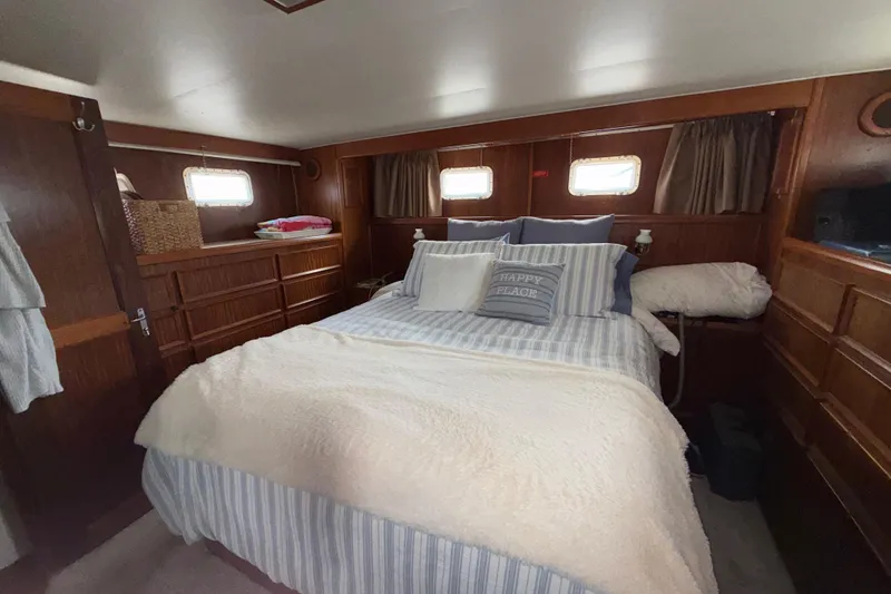 Slide: The Image of Cozy bedroom interior of 1981 Hatteras 43 Motor Yacht with striped bedding and wooden accents. - 47
