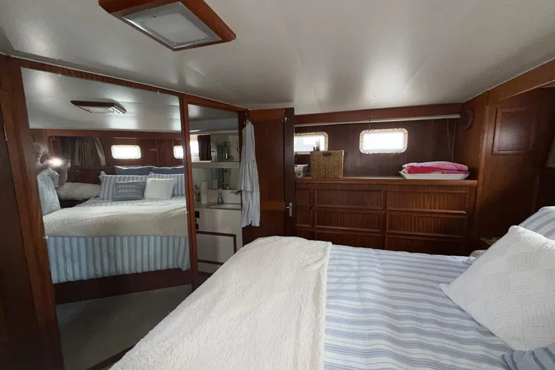 Slide: The Image of Interior of 1981 Hatteras 43 Motor Yacht with cozy bedroom and wooden cabinetry. - 50