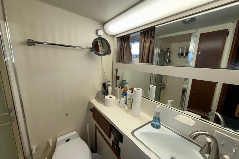 Slide: The Image of Bathroom interior of 1981 Hatteras 43 Motor Yacht with sink, mirror, and toiletries. - 51