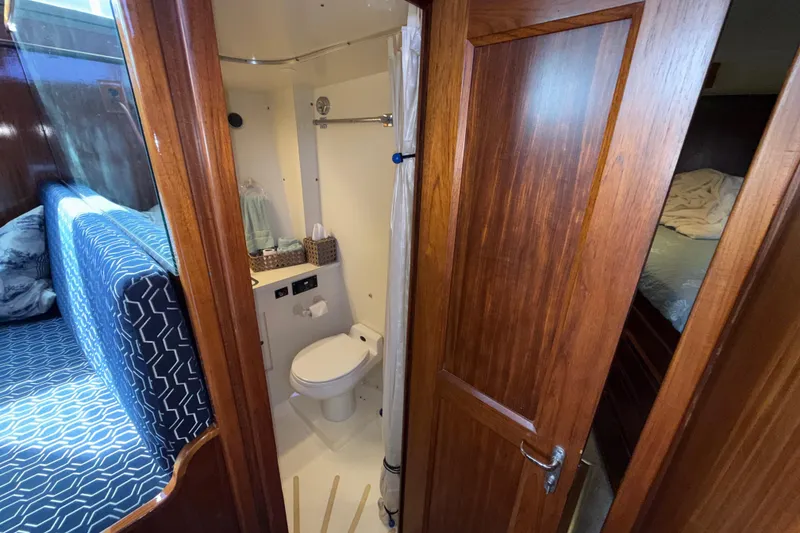 Slide: The Image of Interior of 1981 Hatteras 43 Motor Yacht featuring bathroom and cozy sleeping area. - 56