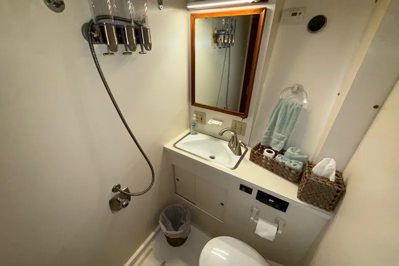 Slide: The Image of Bathroom interior of 1981 Hatteras 43 Motor Yacht with sink, mirror, and shower amenities. - 57