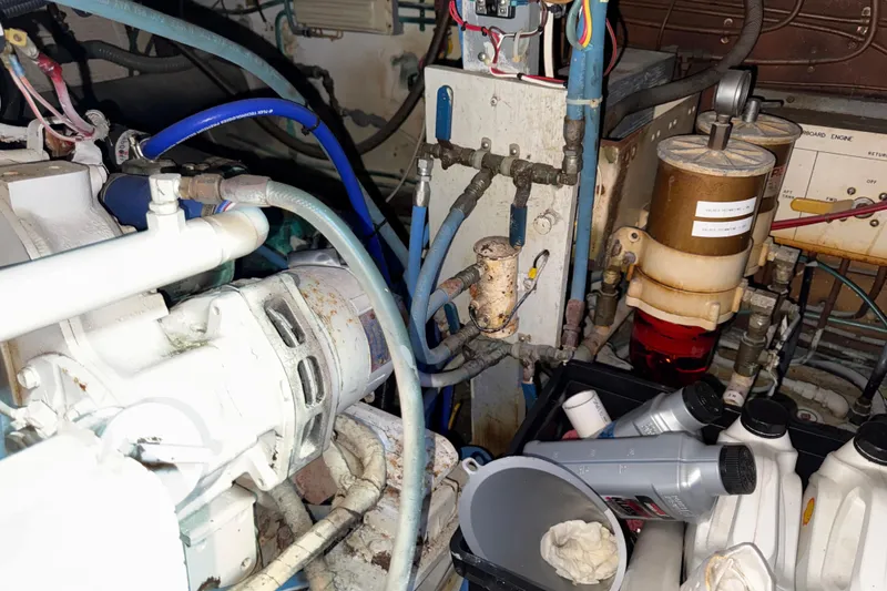 Slide: The Image of Engine room of 1981 Hatteras 43 Motor Yacht with mechanical components and oil containers. - 68