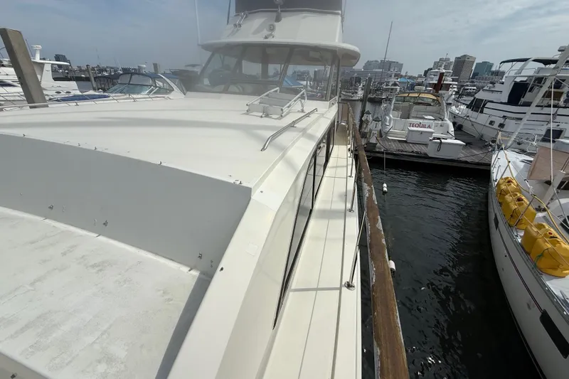Slide: The Image of 1981 Hatteras 43 Motor Yacht docked at marina, surrounded by other boats. - 11