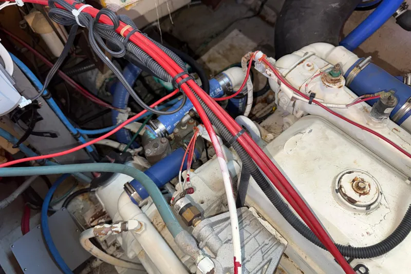 Slide: The Image of Engine compartment of a 1981 Hatteras 43 Motor Yacht with visible wiring and hoses. - 72
