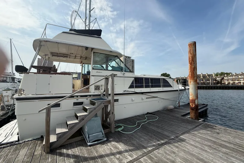 Slide: The Image of 1981 Hatteras 43 Motor Yacht docked at marina under clear sky. - 74