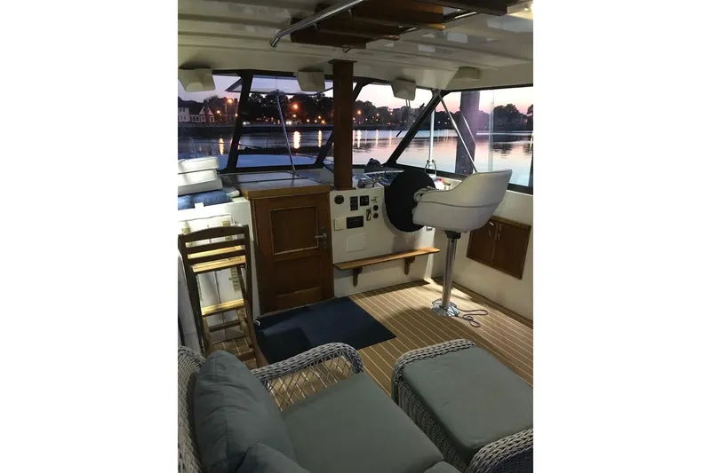 Slide: The Image of Interior of 1981 Hatteras 43 Motor Yacht with helm, seating, and waterfront view. - 23