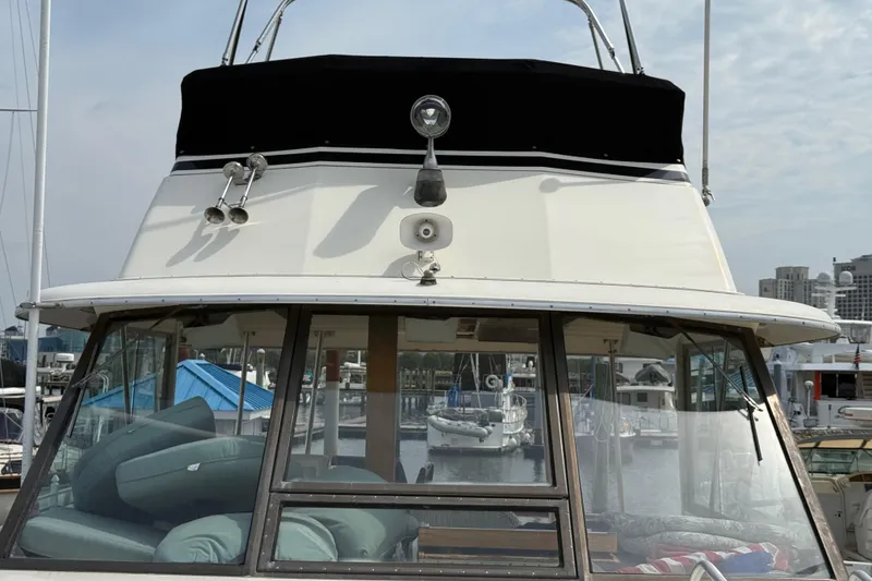 Slide: The Image of 1981 Hatteras 43 Motor Yacht docked at marina, front view with windows and cushions. - 13