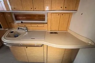 Slide: The Image of 1998 Sea Ray Sundancer 540 yacht kitchen with wooden cabinets and sleek countertop. - 15