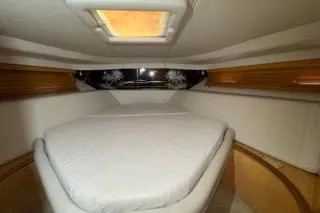 Slide: The Image of 1998 Sea Ray Sundancer 540 cabin interior with bed and wooden accents. - 16