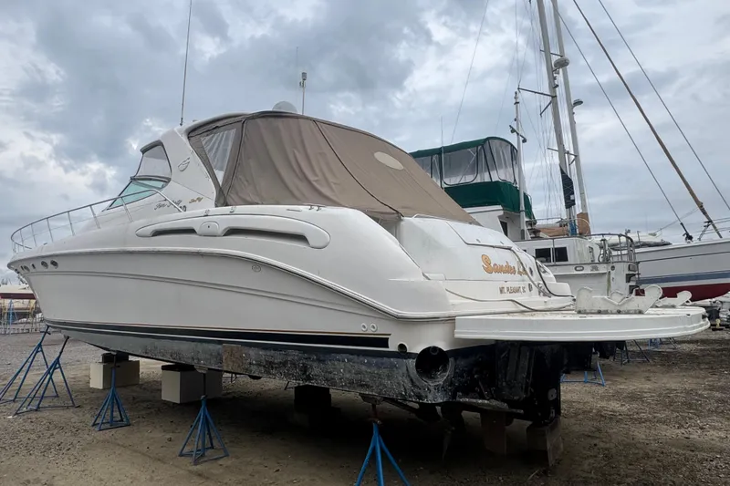 Slide: The Image of 1998 Sea Ray Sundancer 540 yacht on stands, ready for maintenance under cloudy skies. - 3