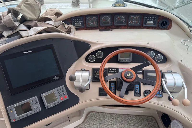 Slide: The Image of Control panel of a 1998 Sea Ray Sundancer 540 yacht with steering wheel and navigation instruments. - 9