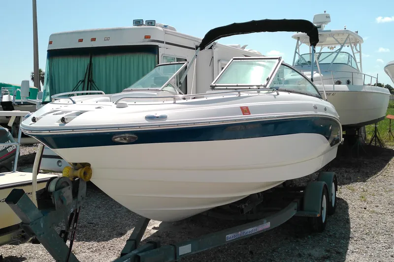 The Image of 2006 Chaparral 236 SSi boat on trailer, parked near RV and other boats. - 0