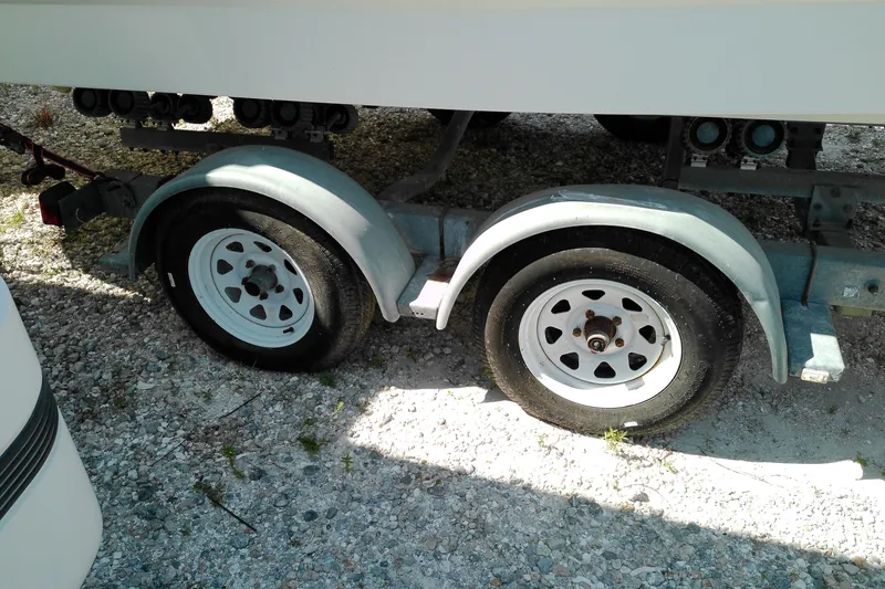 Slide: The Image of Trailer wheels of a 2006 Chaparral 236 SSi boat on gravel surface. - 2