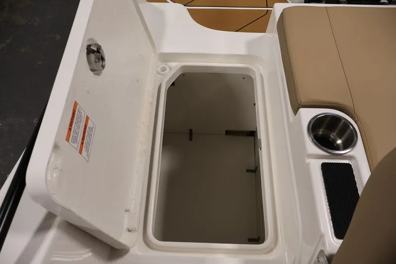 Slide: The Image of 2026 Bayliner D20 boat storage compartment with cup holder and beige seating. - 31