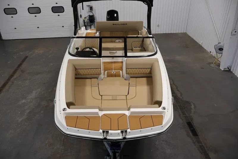 Slide: The Image of 2026 Bayliner D20 boat interior with beige seating, in a garage setting. - 9