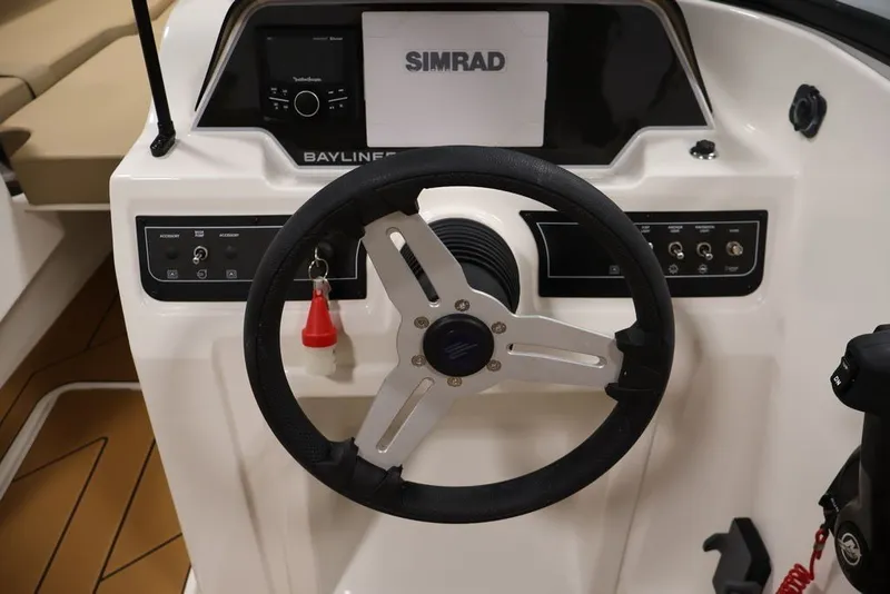 Slide: The Image of 2026 Bayliner D20 boat dashboard with steering wheel and Simrad navigation system. - 13