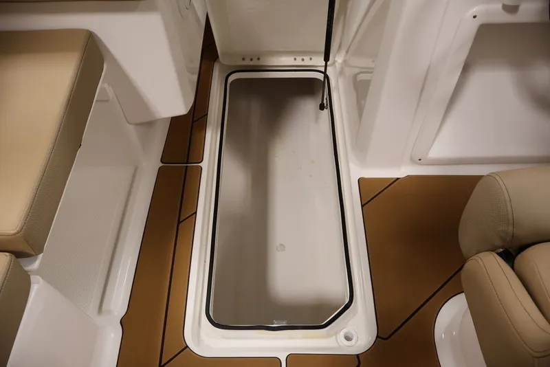 Slide: The Image of 2026 Bayliner D20 boat interior storage compartment with cushioned seating and brown flooring. - 28
