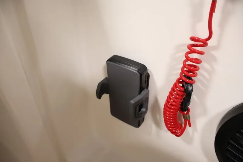Slide: The Image of Red coiled safety cord and holder on 2026 Bayliner D20 boat interior. - 22