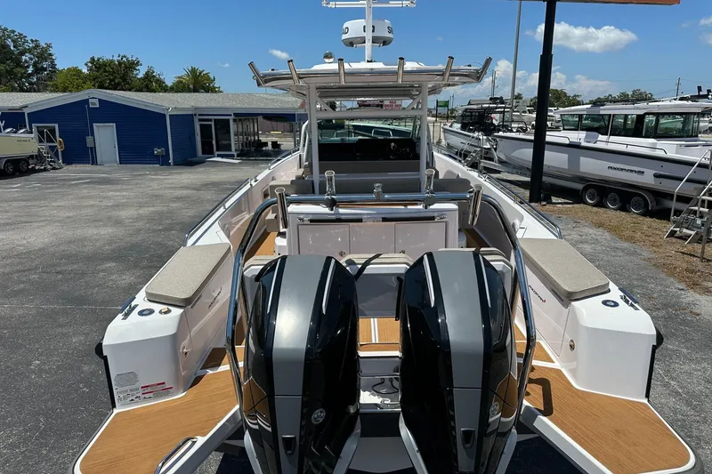 Slide: The Image of 2024 Axopar 37 Sun-Top boat with dual engines, docked at a marina. - 11