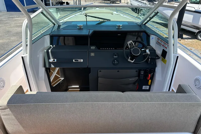 Slide: The Image of 2024 Axopar 37 Sun-Top boat cockpit with steering wheel and seating area. - 22
