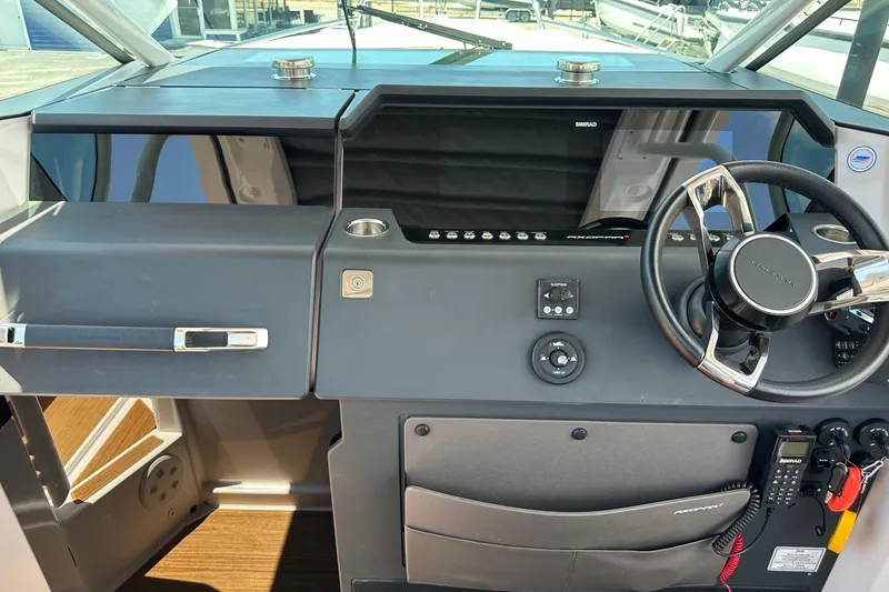 Slide: The Image of 2024 Axopar 37 Sun-Top helm with modern steering and navigation controls. - 23