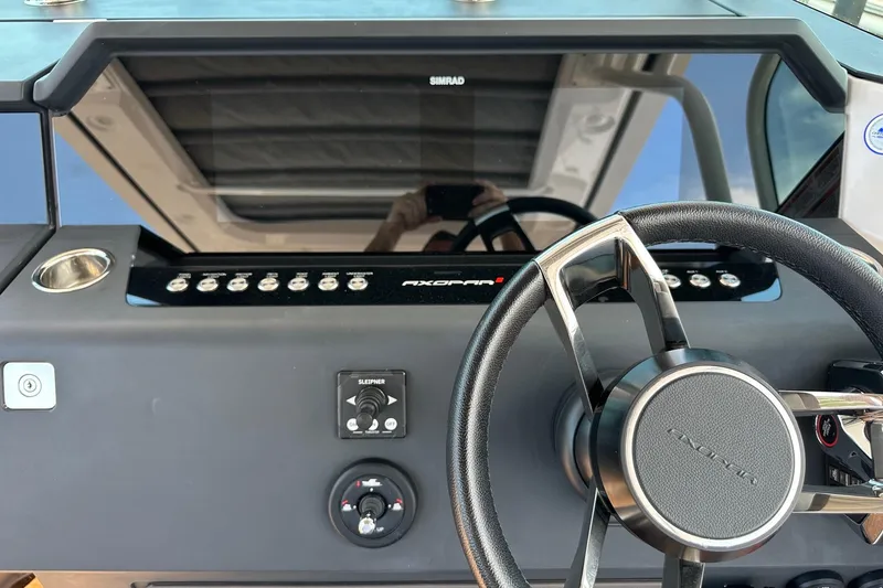 Slide: The Image of 2024 Axopar 37 Sun-Top helm with steering wheel and control panel. - 24