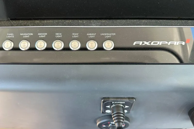 Slide: The Image of Control panel of 2024 Axopar 37 Sun-Top boat with various light switches. - 28