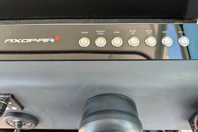 Slide: The Image of Control panel of 2024 Axopar 37 Sun-Top boat with labeled buttons for various functions. - 29