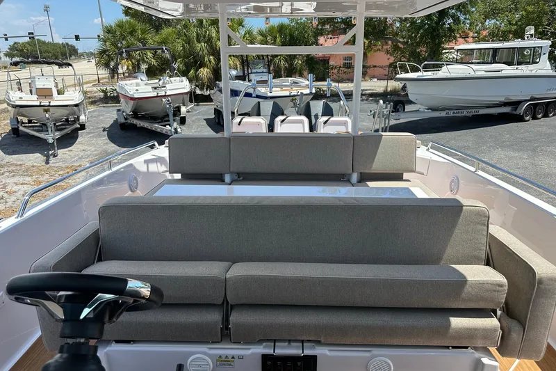 Slide: The Image of 2024 Axopar 37 Sun-Top boat interior with cushioned seating and steering wheel. - 31