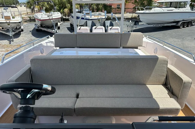 Slide: The Image of 2024 Axopar 37 Sun-Top boat interior with comfortable seating and steering wheel. - 32