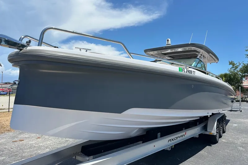 Slide: The Image of 2024 Axopar 37 Sun-Top boat on trailer under clear blue sky. - 4