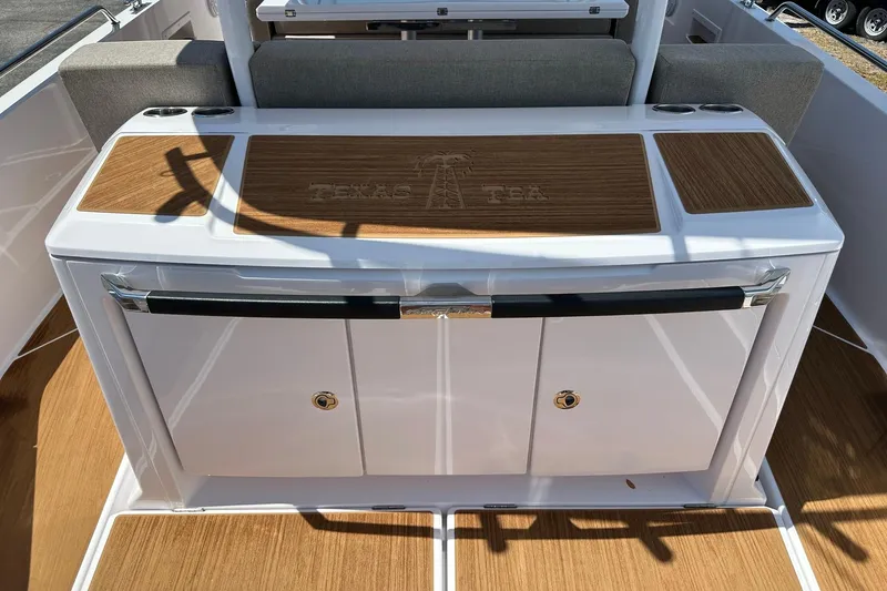 Slide: The Image of 2024 Axopar 37 Sun-Top boat interior with teak accents and storage compartments. - 42