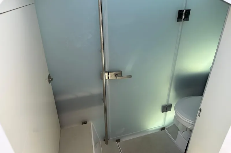 Slide: The Image of Modern bathroom interior on 2024 Axopar 37 Sun-Top boat, featuring sleek design and frosted glass door. - 49