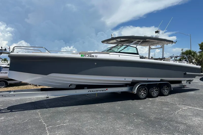 Slide: The Image of 2024 Axopar 37 Sun-Top boat on trailer under cloudy sky. - 5