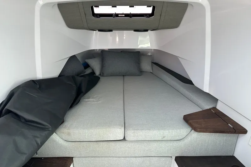 Slide: The Image of 2024 Axopar 37 Sun-Top cabin interior with gray cushions and wooden accents. - 52
