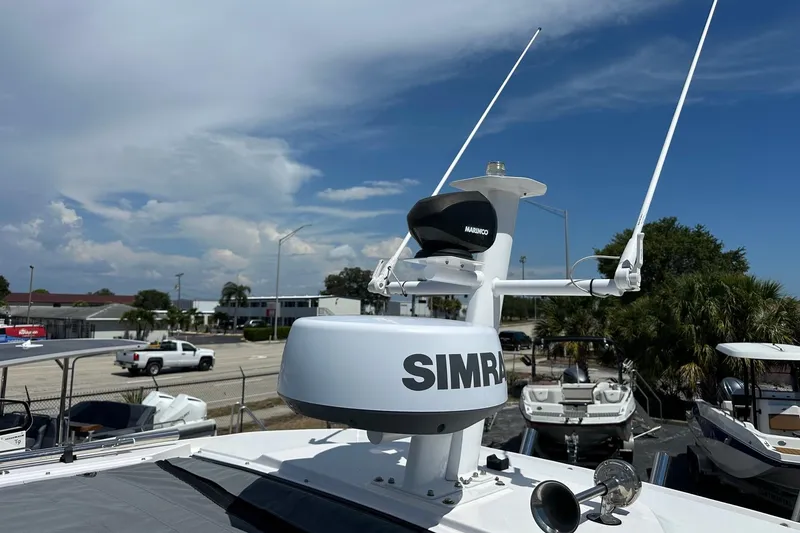 Slide: The Image of 2024 Axopar 37 Sun-Top boat with Simrad radar and antennas, parked outdoors. - 56