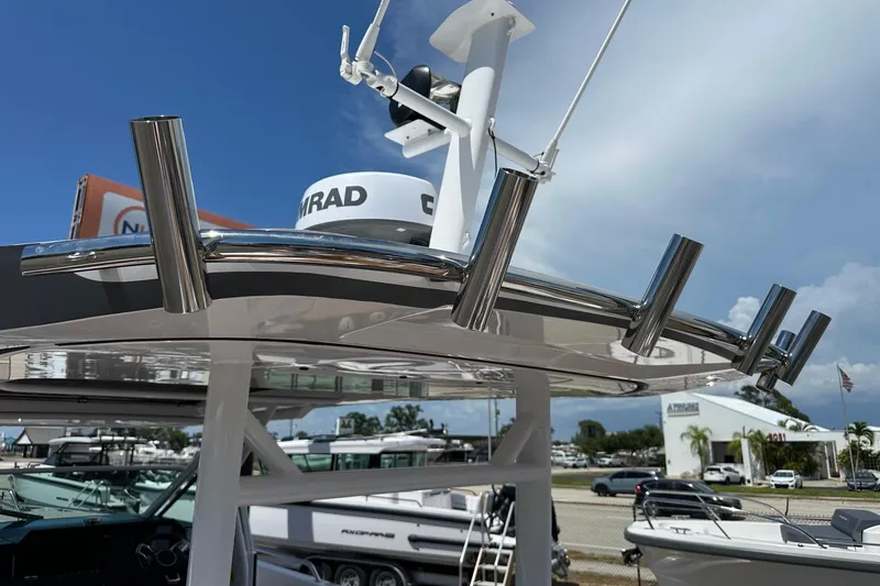 Slide: The Image of 2024 Axopar 37 Sun-Top boat with radar and rod holders under clear sky. - 58