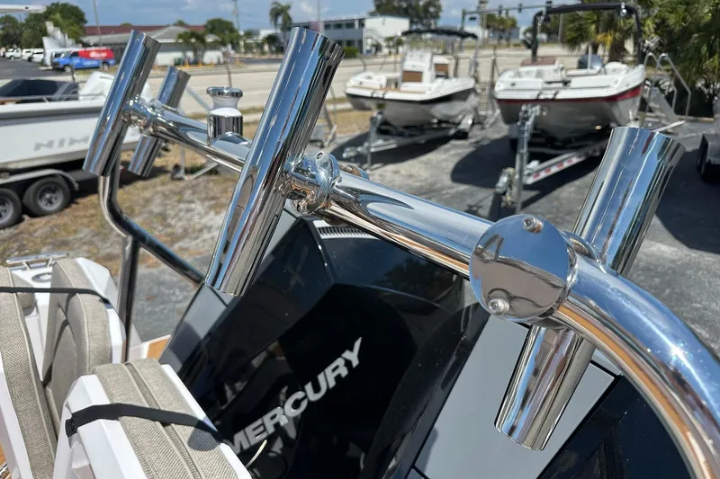 Slide: The Image of Chrome rod holders on a 2024 Axopar 37 Sun-Top boat, with Mercury engine visible. - 59