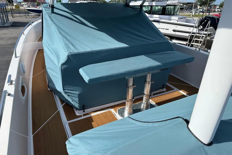 Slide: The Image of 2024 Axopar 37 Sun-Top boat with blue covers and wooden deck. - 69