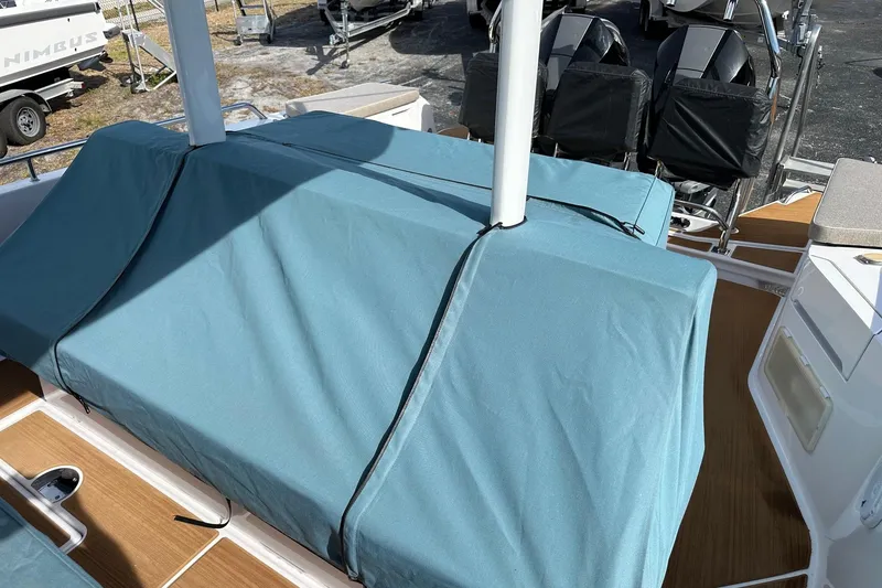 Slide: The Image of 2024 Axopar 37 Sun-Top boat with blue protective cover on deck. - 70